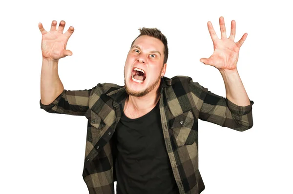 Young crazy guy scares like a devil with hands up isolated on background. — Stock Photo, Image