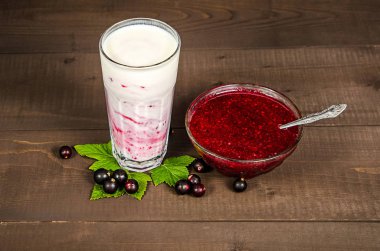 Bir bardak yoğurt kokteyli, meyve suyu, ahududulu, reçelli ağaç gövdesi üzerinde, ahşap arka planda..