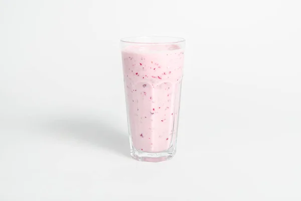 Verre de cocktail de yaourts, smoothies, avec des framboises se dresse sur une souche de bouleau, isolé sur fond blanc . — Photo