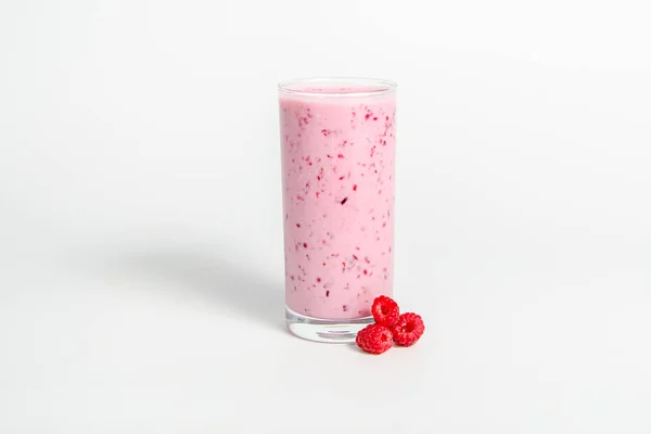 Verre de cocktail de yaourts, smoothies, avec des framboises se dresse sur une souche de bouleau, isolé sur fond blanc . — Photo