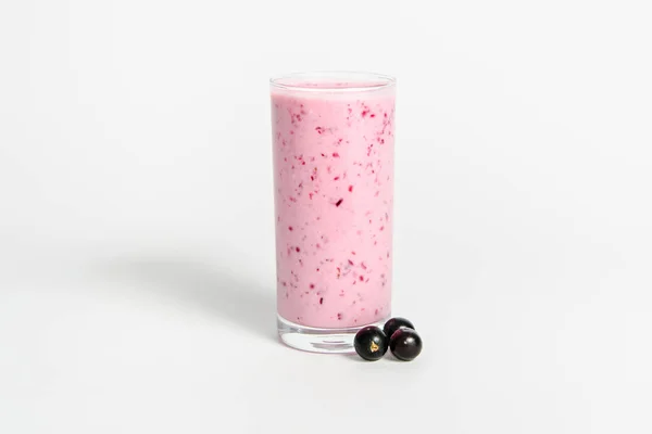 Szklanka koktajlu jogurtowego, koktajle, z jagodami czarnej porzeczki, stoi na brzozowym pniu na białym tle. — Zdjęcie stockowe