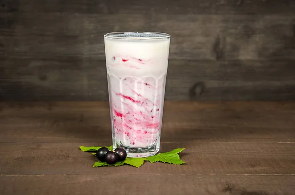 Verre de yaourt cocktail, smoothies, avec des framboises se tient sur une souche de bouleau, sur fond de bois. — Photo