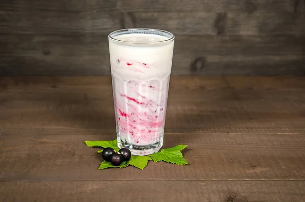 Verre de yaourt cocktail, smoothies, avec des framboises se tient sur une souche de bouleau, sur fond de bois. — Photo