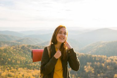 Dağlarda sonbahar ormanlarında yürüyüş yapan bir kadın. Doğada eğlence ve sağlıklı yaşam tarzı..