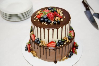 Gelin ve damat, düğün pastasını çikolata ve böğürtlen ile keser.