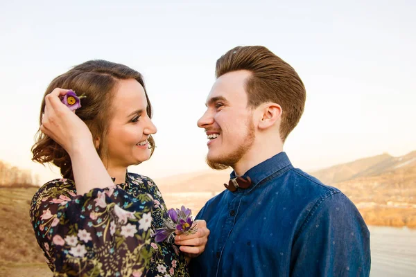 Par i kärlek glada promenader och omfamna på floden bakgrund — Stockfoto