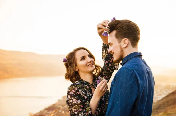 Par i kärlek glada promenader och omfamna på floden bakgrund — Stockfoto