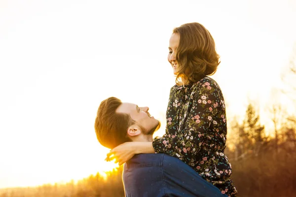 Par i kärlek glada promenader och omfamna på floden bakgrund — Stockfoto