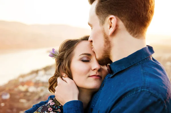 Par i kärlek glada promenader och omfamna på floden bakgrund — Stockfoto