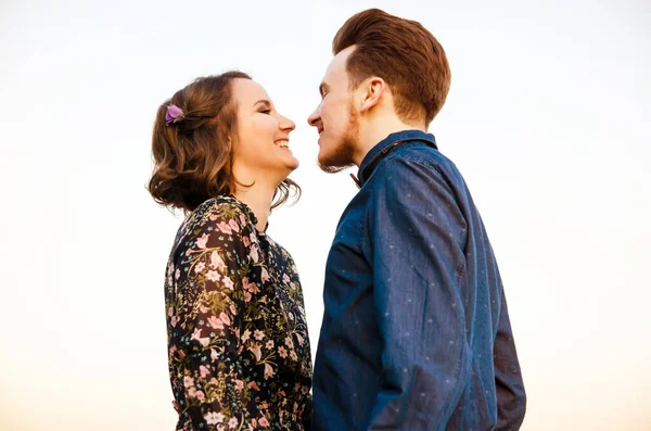 Par i kärlek glada promenader och omfamna på floden bakgrund — Stockfoto