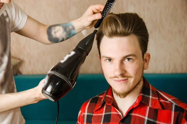 Cabeleireiro faz pompadour estilo de cabelo para um jovem — Fotografia de Stock