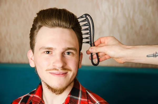 Peluquero peina pompadour a un joven —  Fotos de Stock