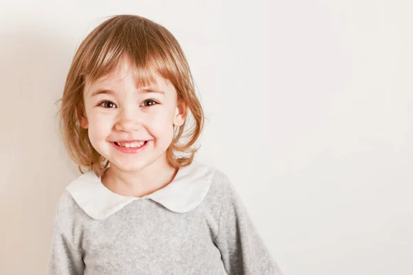 Close up retrato de bela menina sorri em um fundo leve — Fotografia de Stock