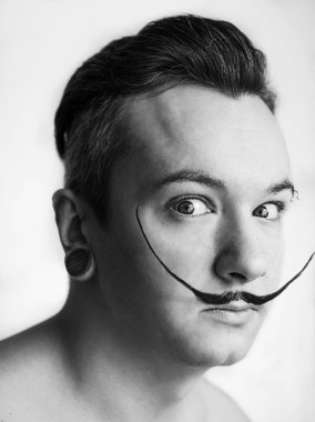 Bıyıklı beyaz adam Salvador Dali 'yi canlandırıyor.