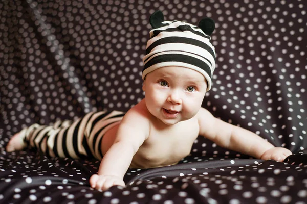 Portgait de pequeno bebê feliz de seis meses de idade em preto no fundo de ervilhas — Fotografia de Stock