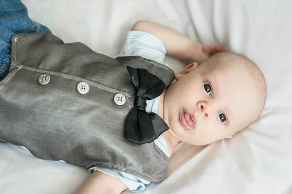 Primer plano retrato de un niño de tres meses acostado sobre un fondo de trapo claro, vista superior . — Foto de Stock