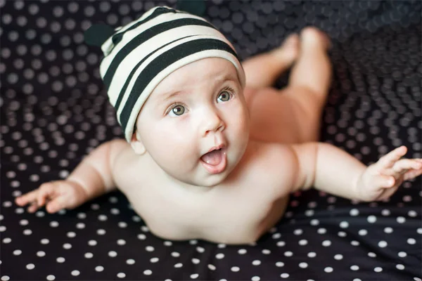 Portgait de pequeno bebê feliz de seis meses de idade em preto no fundo de ervilhas — Fotografia de Stock