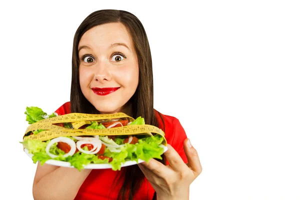 Young woman holds plate with salad and fork with tomato, isolated on white background. — 스톡 사진