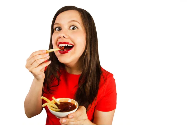 Una giovane donna mangia patatine con ketchup. Isolato su sfondo bianco . — Foto Stock