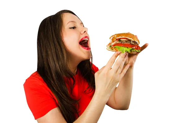 Giovane donna grassa tiene hamburger, sorrisi con la bocca aperta isolato su sfondo bianco . — Foto Stock