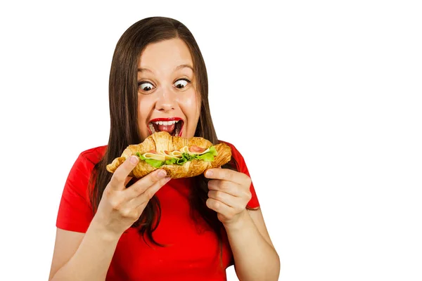 Ung kvinna äter croissant med skinka och ost, isolerad på vit bakgrund. — Stockfoto