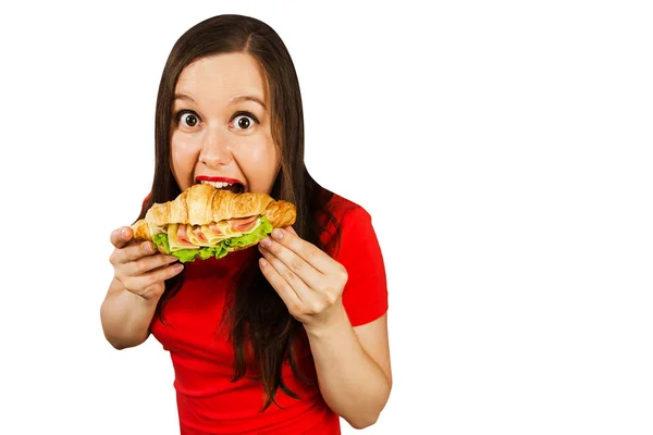 Young woman eats croissant with ham and cheese, isolated on white background. — 스톡 사진