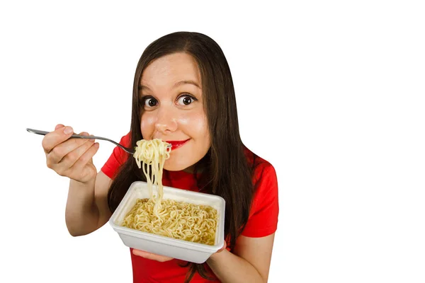 Jong meisje in een rood t-shirt eet Chinese noedels met stokjes geïsoleerd op een witte achtergrond. — Stockfoto