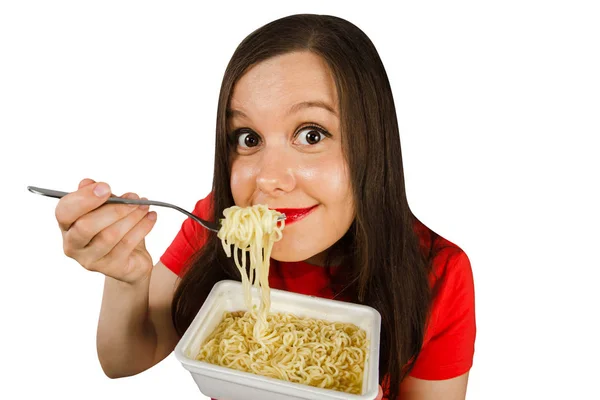 Giovane ragazza in una t-shirt rossa mangia tagliatelle cinesi con bacchette isolate su uno sfondo bianco . — Foto Stock