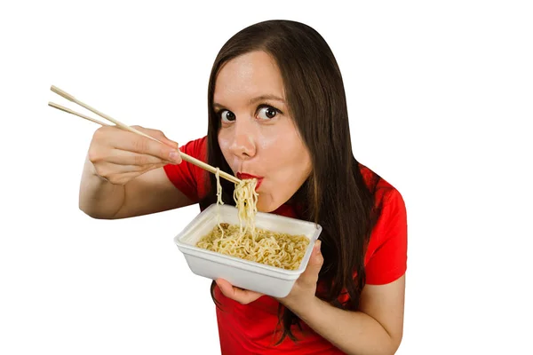 Young girl in a red t shirt eats chinese noodles with chopsticks isolated on a white background. — 스톡 사진