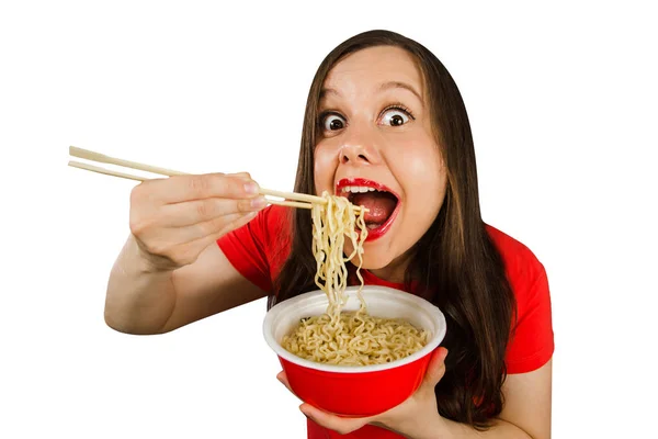 Young girl in a red t shirt eats chinese noodles with chopsticks isolated on a white background. — 스톡 사진