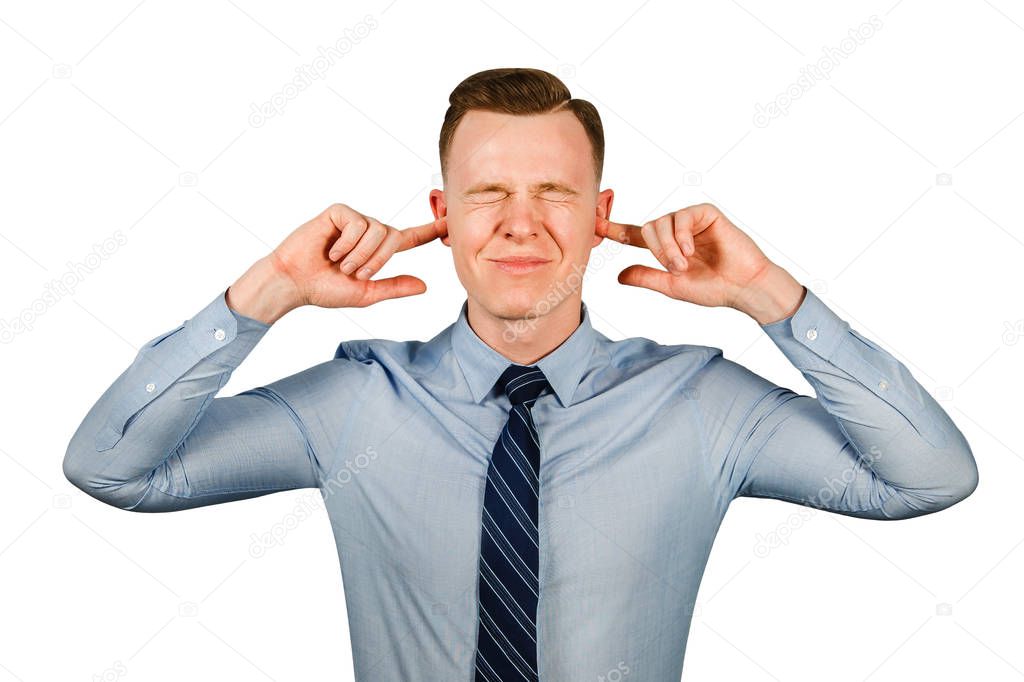 Young businessman dressed in blue shirt and tie closing his ears and eyes, isolated on white background.