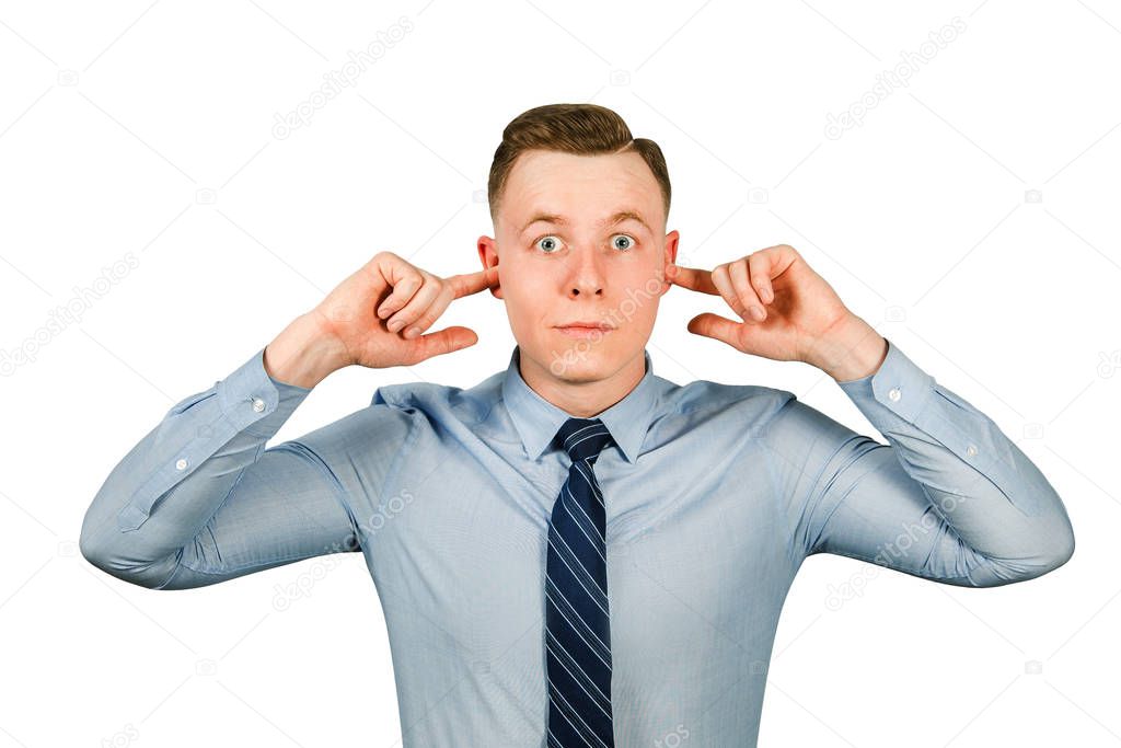 Young businessman dressed in blue shirt and tie closing his ears from noise, isolated on white background.