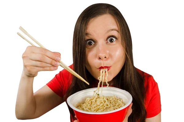 Young girl in a red t shirt eats chinese noodles with chopsticks isolated on a white background. — 스톡 사진