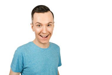 Mavi tişörtlü, izole beyaz arka planda gülümseyen genç adamın yakın portresi..