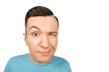 İzole edilmiş beyaz bir arka planda mavi tişörtlü genç adam..