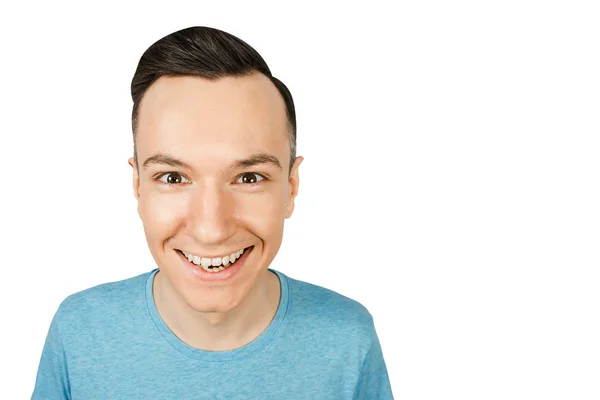 Retrato de cerca de un joven sonriente feliz, vestido con una camiseta azul sobre un fondo aislado de luz blanca . —  Fotos de Stock