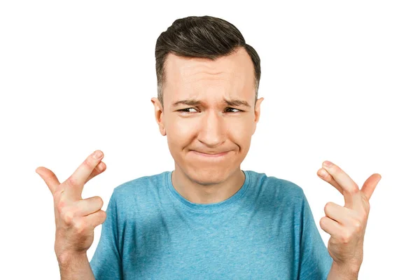 Young guy dressed in a blue t shirt crossed fingers In hope on a isolated white background. — Stock Photo, Image