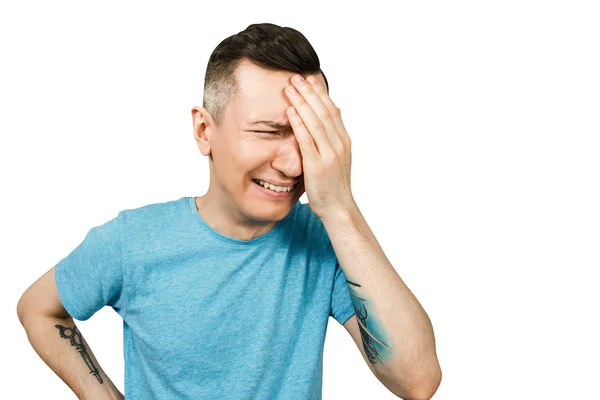 Young crying guy cover face with hands with open mouth, dressed in a blue t shirt on a isolated white background. — Stock Photo, Image