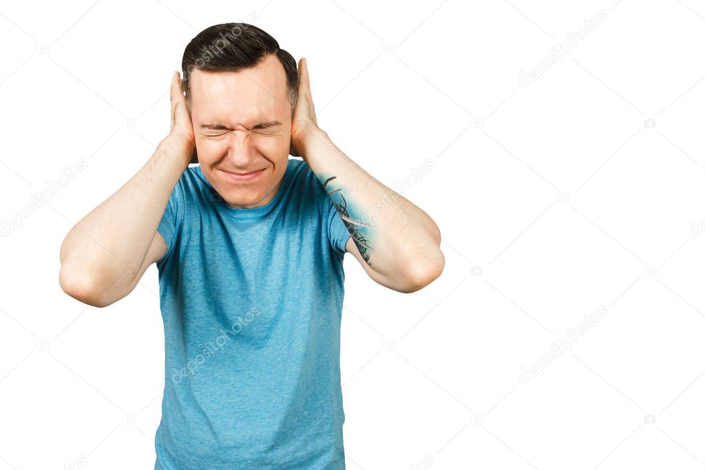 Young guy dressed in a blue t-shirt closing ears and cry on a isolated white background.