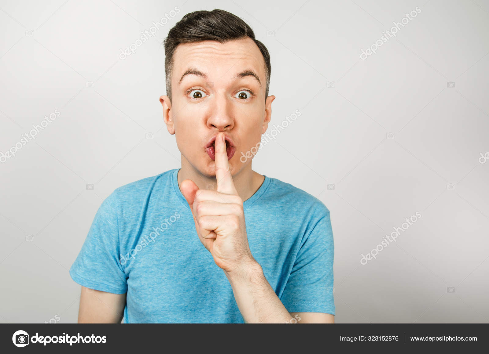 Young guy shut your mouth with finger dressed in a blue t shirt on a