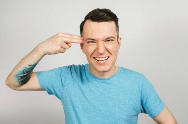 Adam arka planda şakak parmağına silah dayamış.