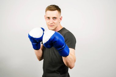 Arka planda boks eldivenli genç adam..