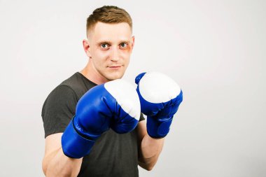 Arka planda boks eldivenli genç adam..