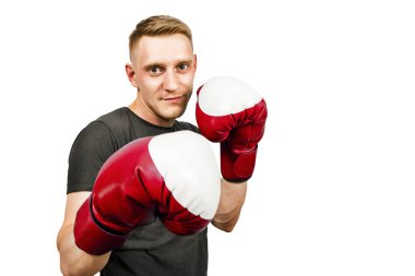 Genç bir adam boks eldiveninde yumruğunu çırpıyor. Beyaz arka planda izole edilmiş. Yan görünüm.