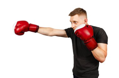 Genç bir adam boks eldiveninde yumruğunu çırpıyor. Beyaz arka planda izole edilmiş. Yan görünüm.