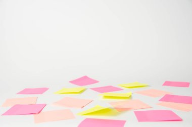 Pembe ve sarı çıkartmalar ve defter açık arkaplanda yatıyor..