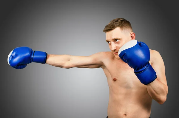 Young man in boxing gloves on a light background. — Stock Photo, Image