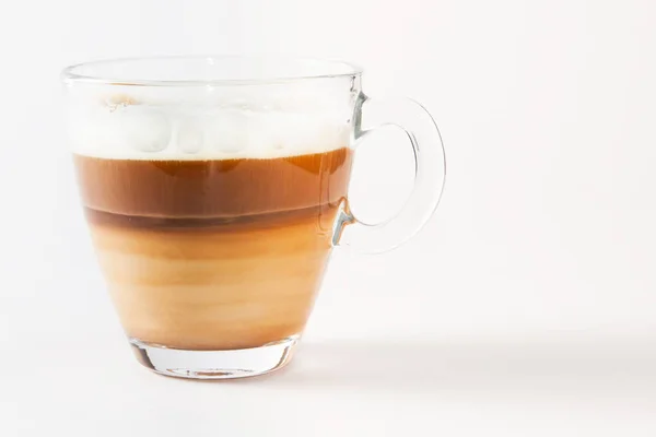 Café capuchino en una taza transparente y platillo sobre un fondo blanco — Foto de Stock