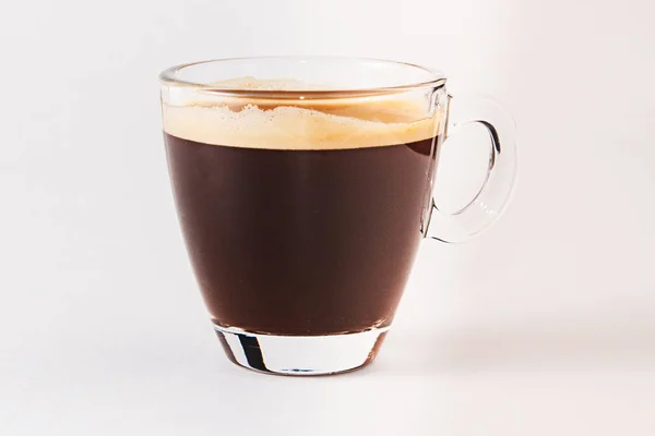 Café americano dans une tasse transparente et une soucoupe sur fond blanc — Photo