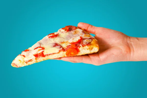 Hand holds piece of pizza isolated on orange background. — 스톡 사진